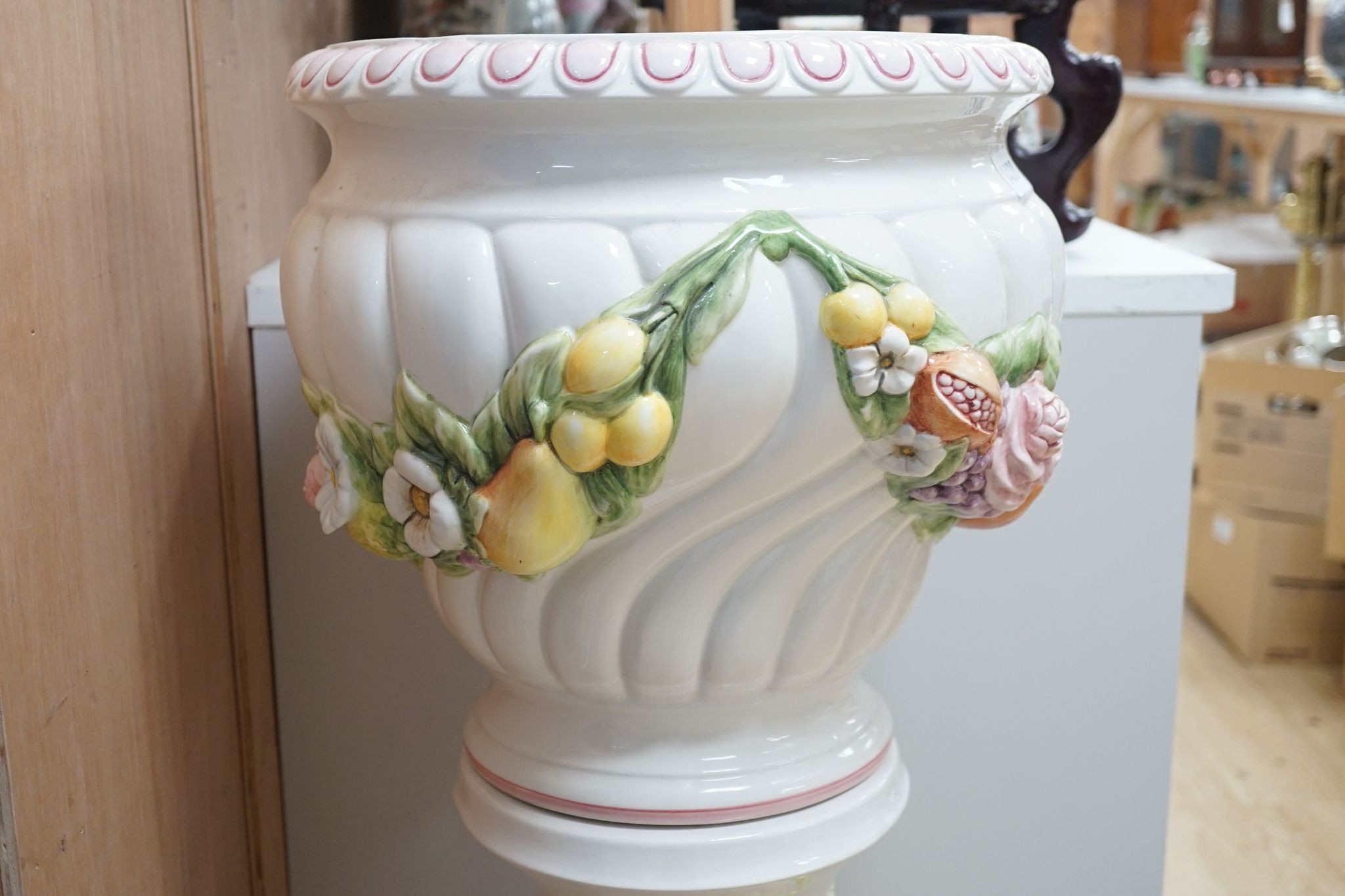 A modern Italian pottery jardiniere and stand, with floral and fruit decoration, 104 cms high.